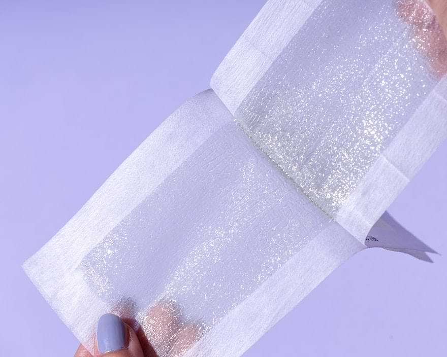 una ragazza prepara le strisce di ceretta a strappo