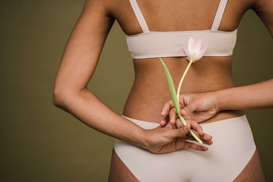 ragazza di schiena tiene un tulipano rosa tra le mani